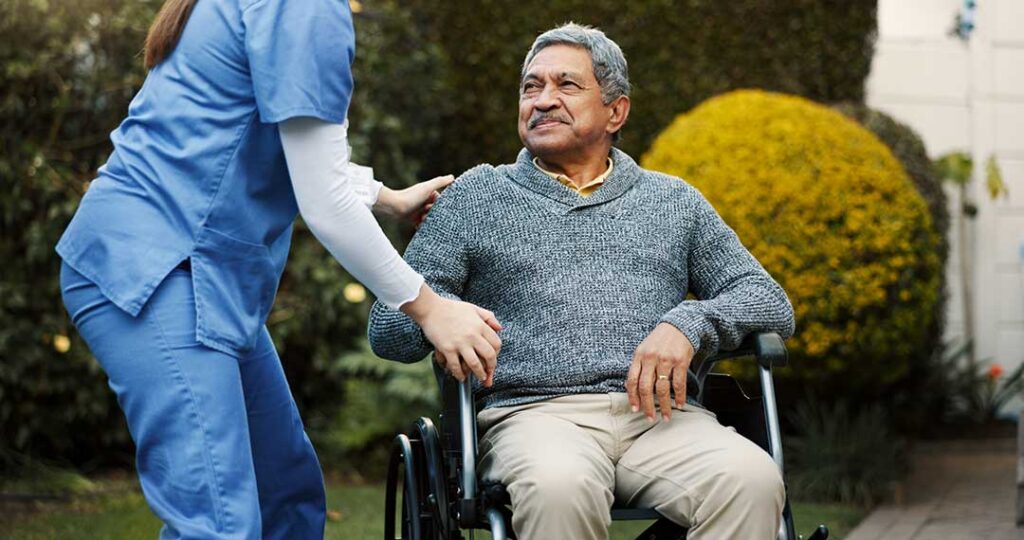 Older resident reviewing care documents with a family member at a quiet assisted living table.